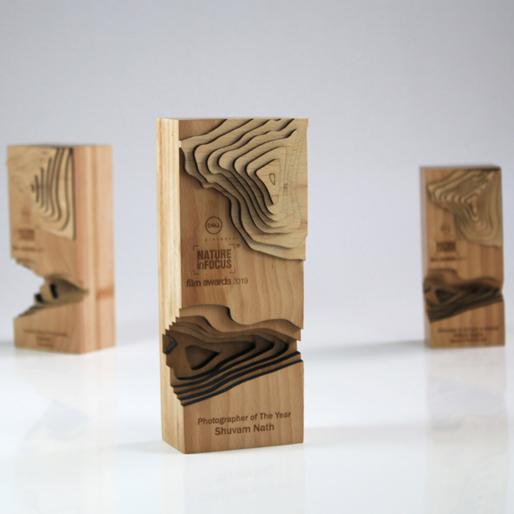 Three wooden awards with intricate designs on them