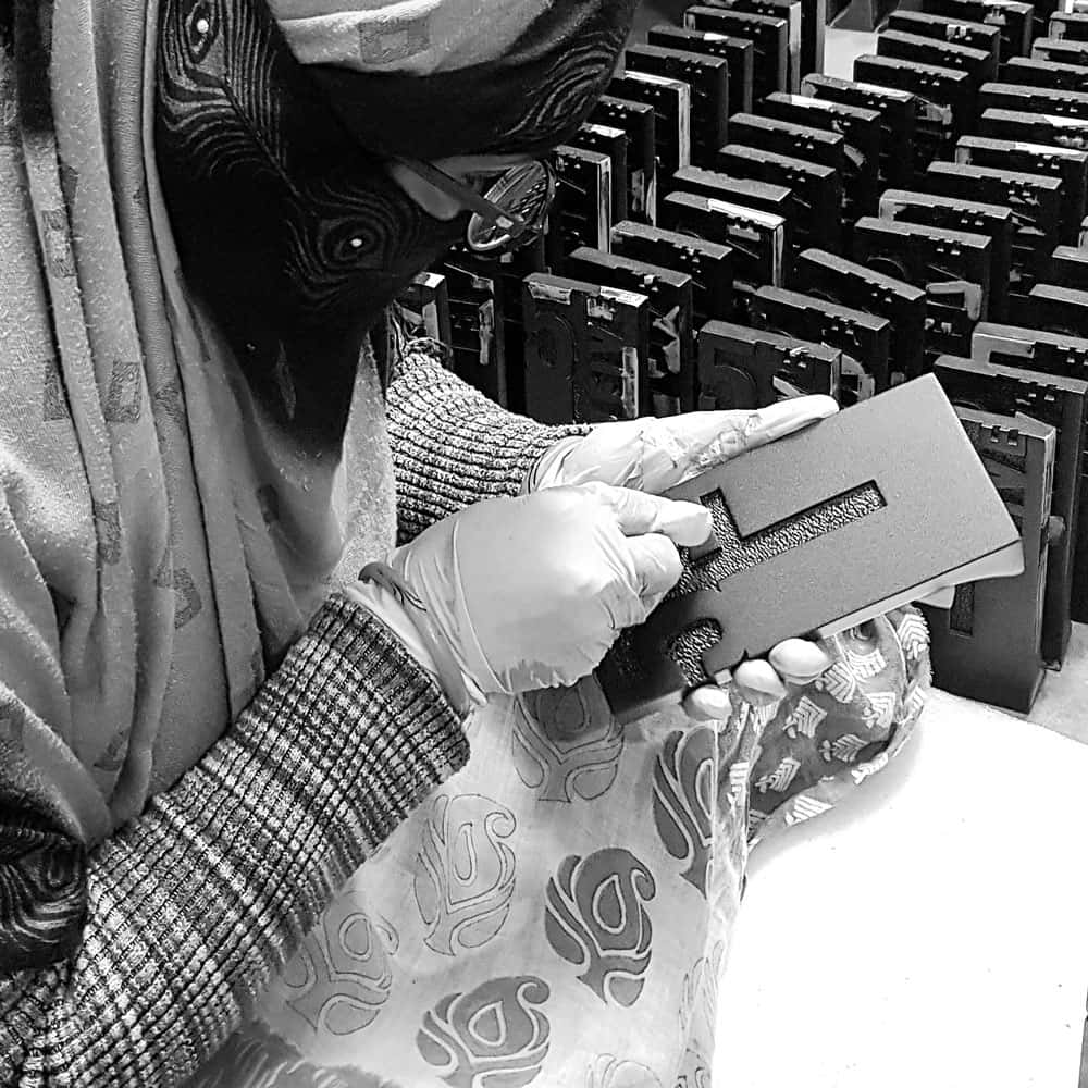 A woman focused on the award diligently working in a factory setting.