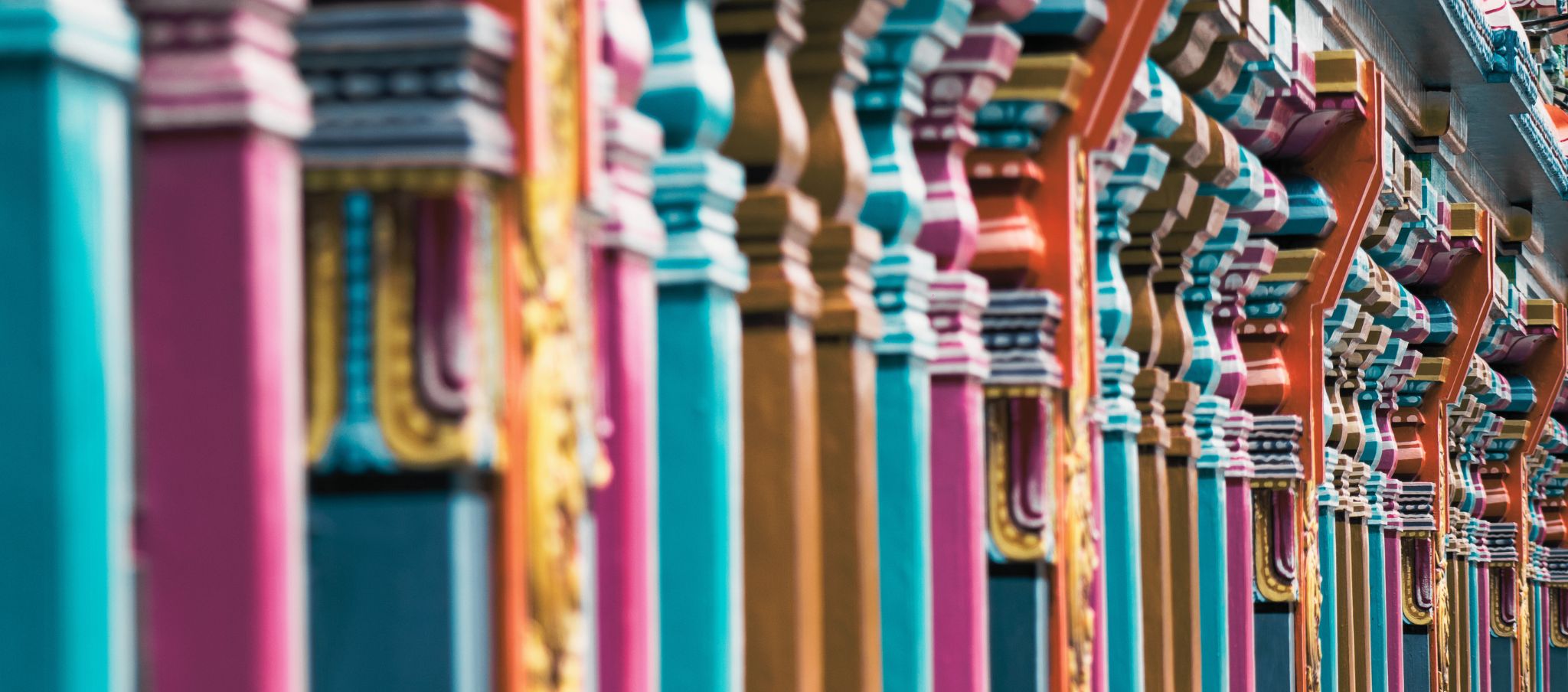 A row of colorfully painted wooden pillars
