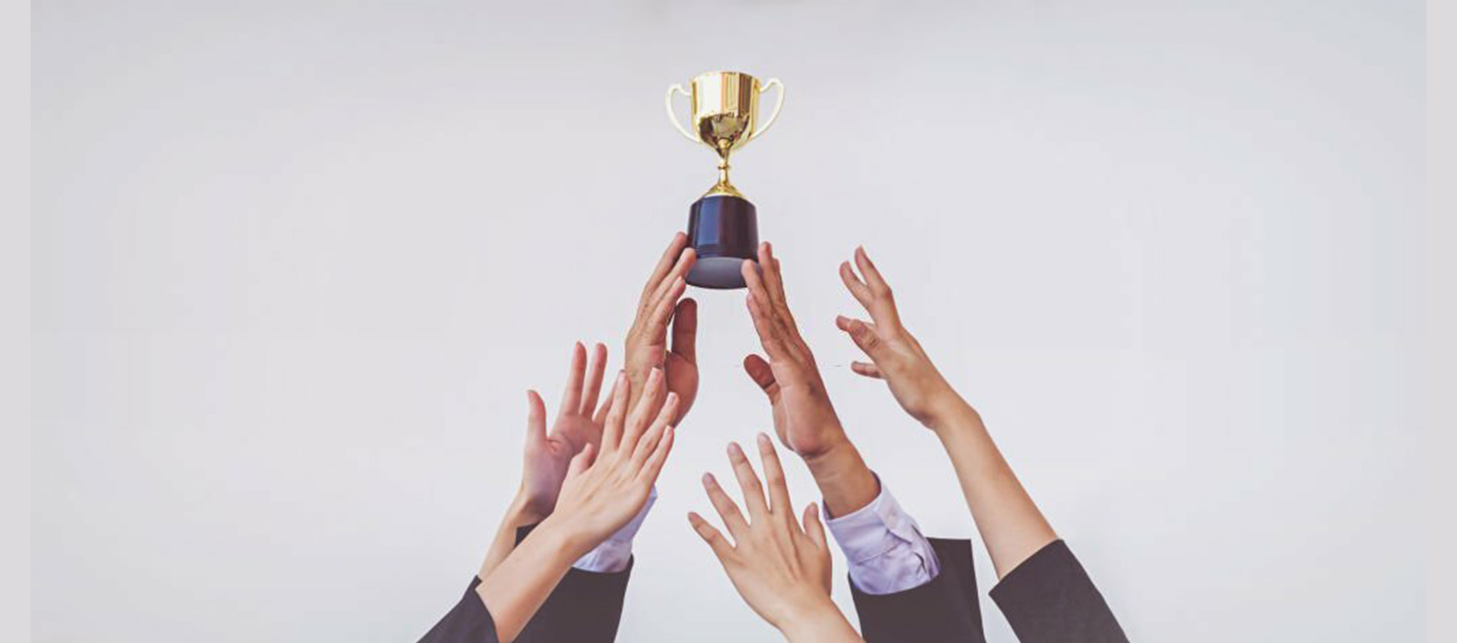 A group of business people holding up a trophy.